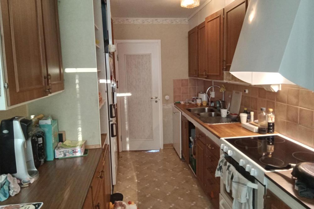 Äldre kök innan renovering, med träskåp och träbänk