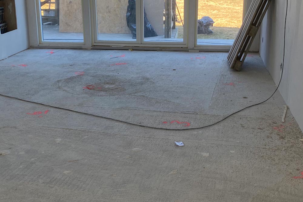 Betonggolv innan installation av helstav parkett, med en EU-pall i bakgrunden