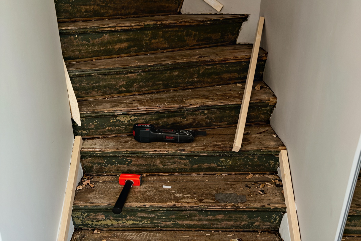 Mörk trätrappa i helstav innan renovering